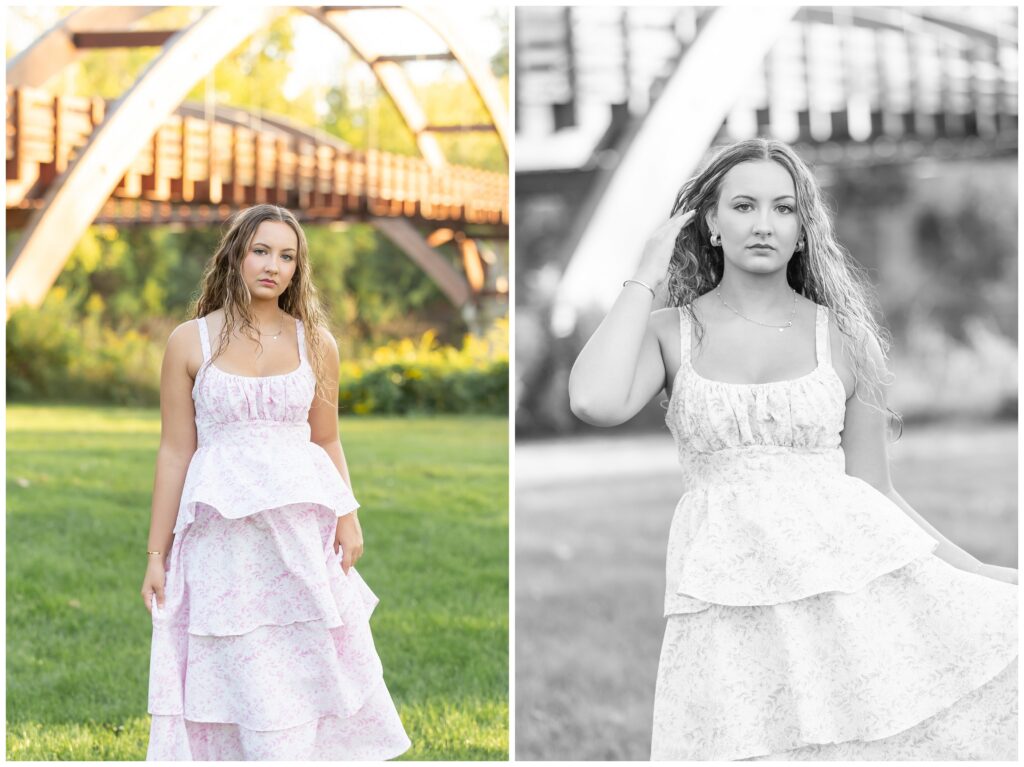 A young woman with curly hair wears a tiered floral dress, standing confidently in a park. A wooden bridge arches in the background, with greenery around. The left image is in color, capturing a serene, vibrant atmosphere, while the right is in black and white, highlighting her thoughtful expression.