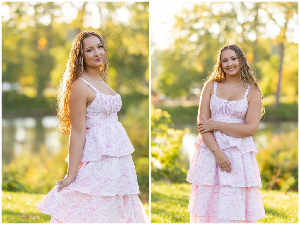 A young woman wearing a light pink, floral dress poses outdoors with sunlight filtering through trees. She smiles gently, with a serene, cheerful mood.